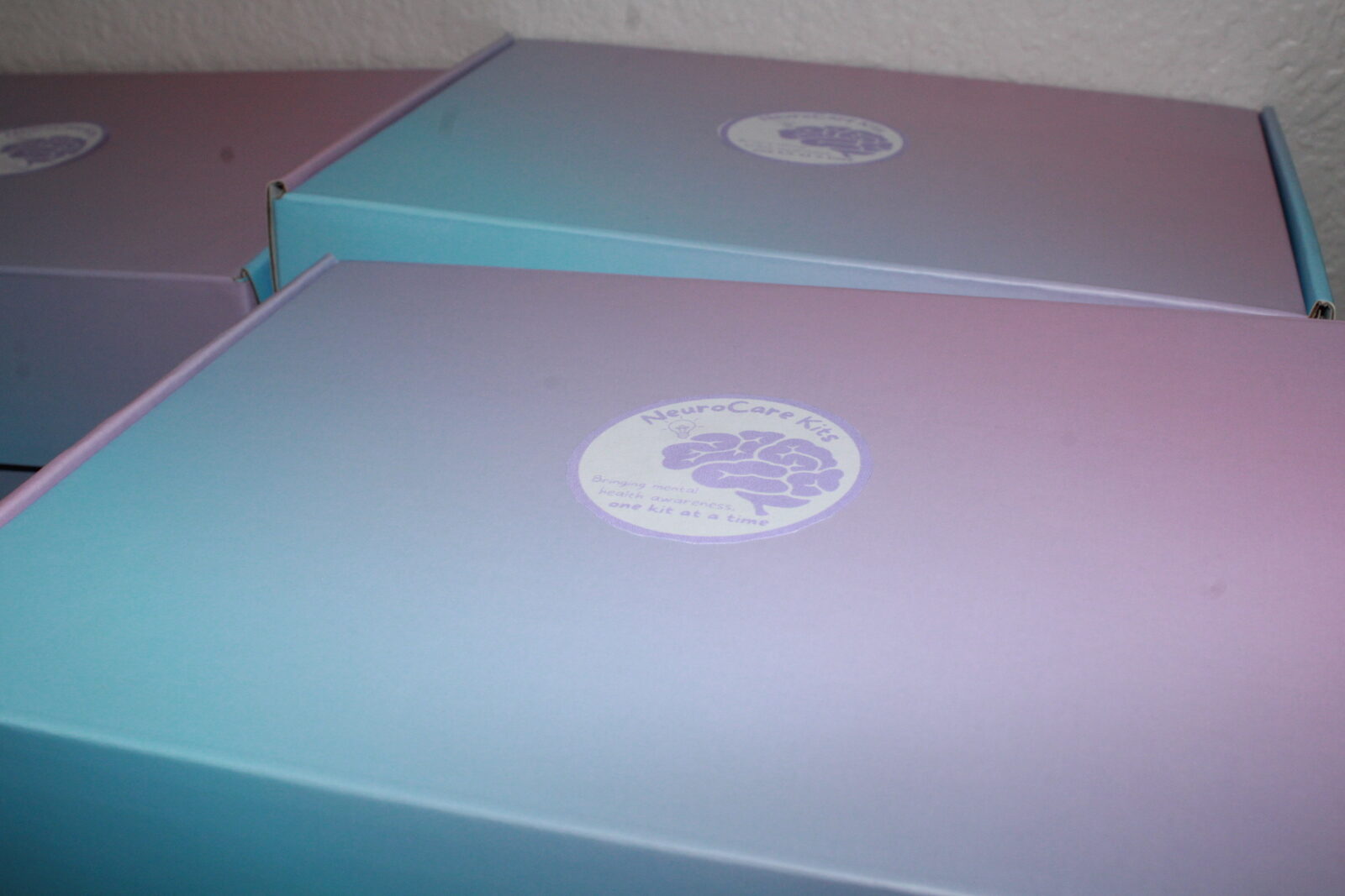 Volunteers sitting with stacks of finished NeuroCare boxes