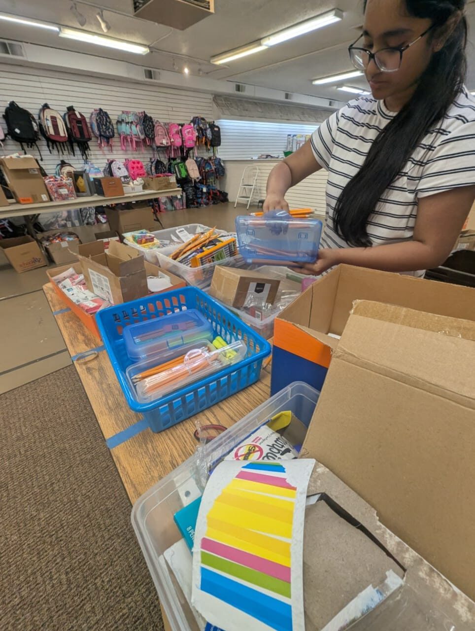 Volunteer sorting school supplies into bins