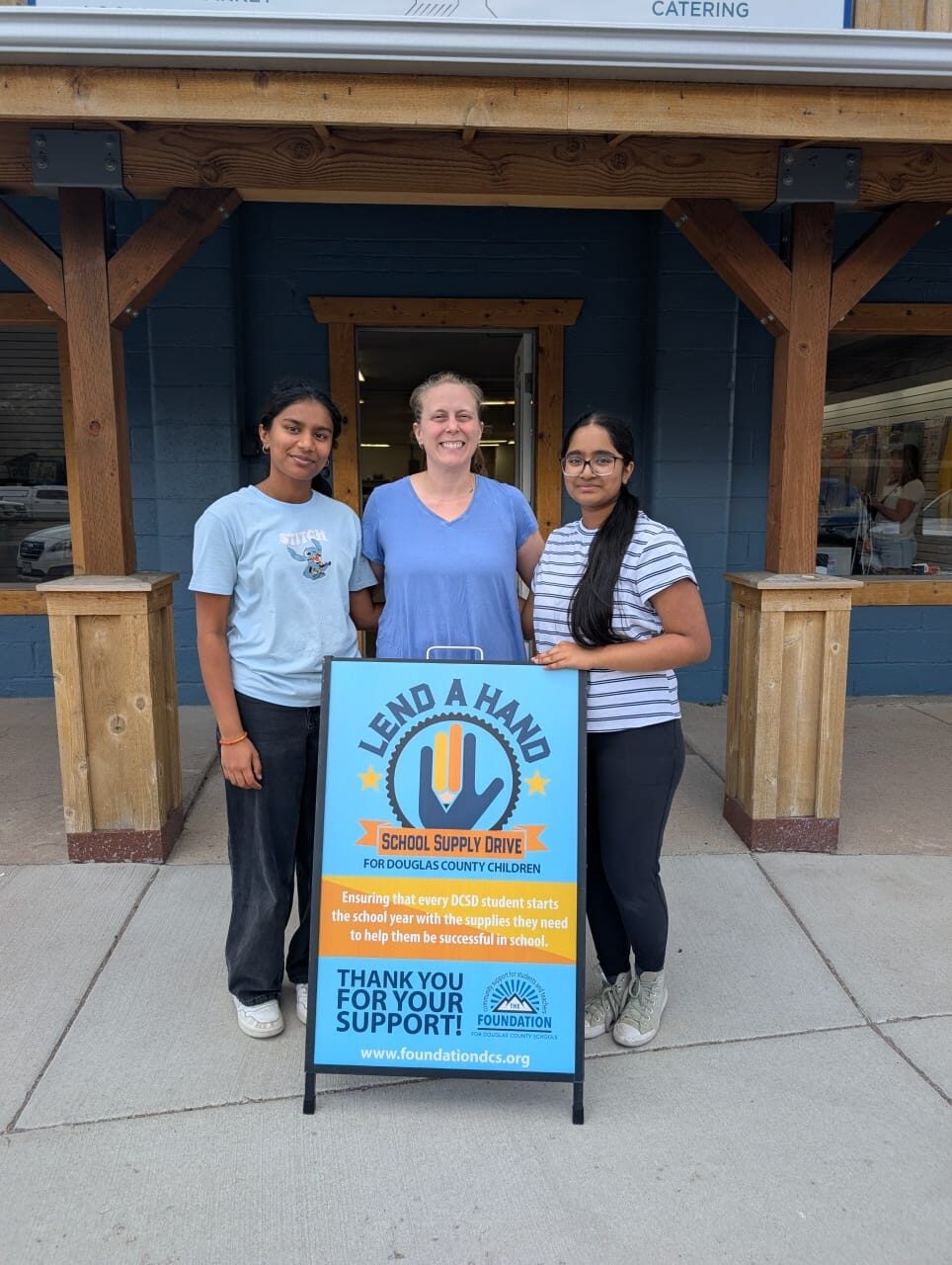 NeuroCare Kits volunteers with the Lend a Hand School Supply Drive sign