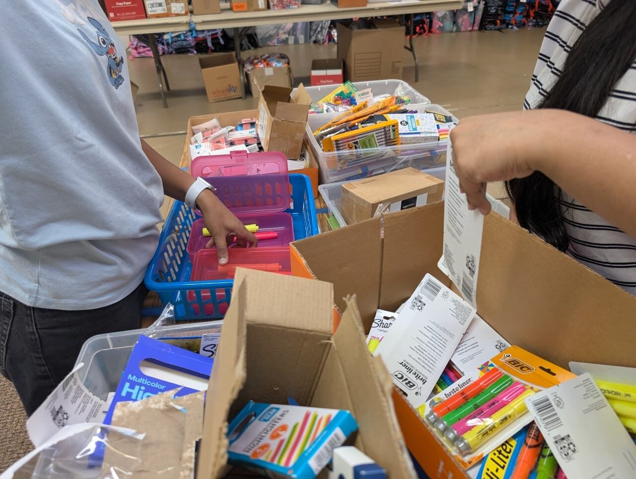 Volunteers organizing highlighters and markers for donation