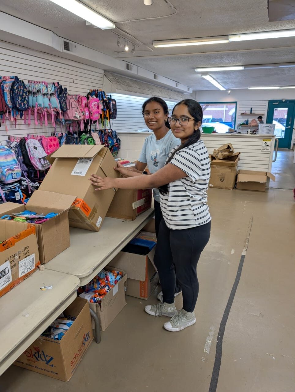 Volunteers packing boxes of donated school supplies